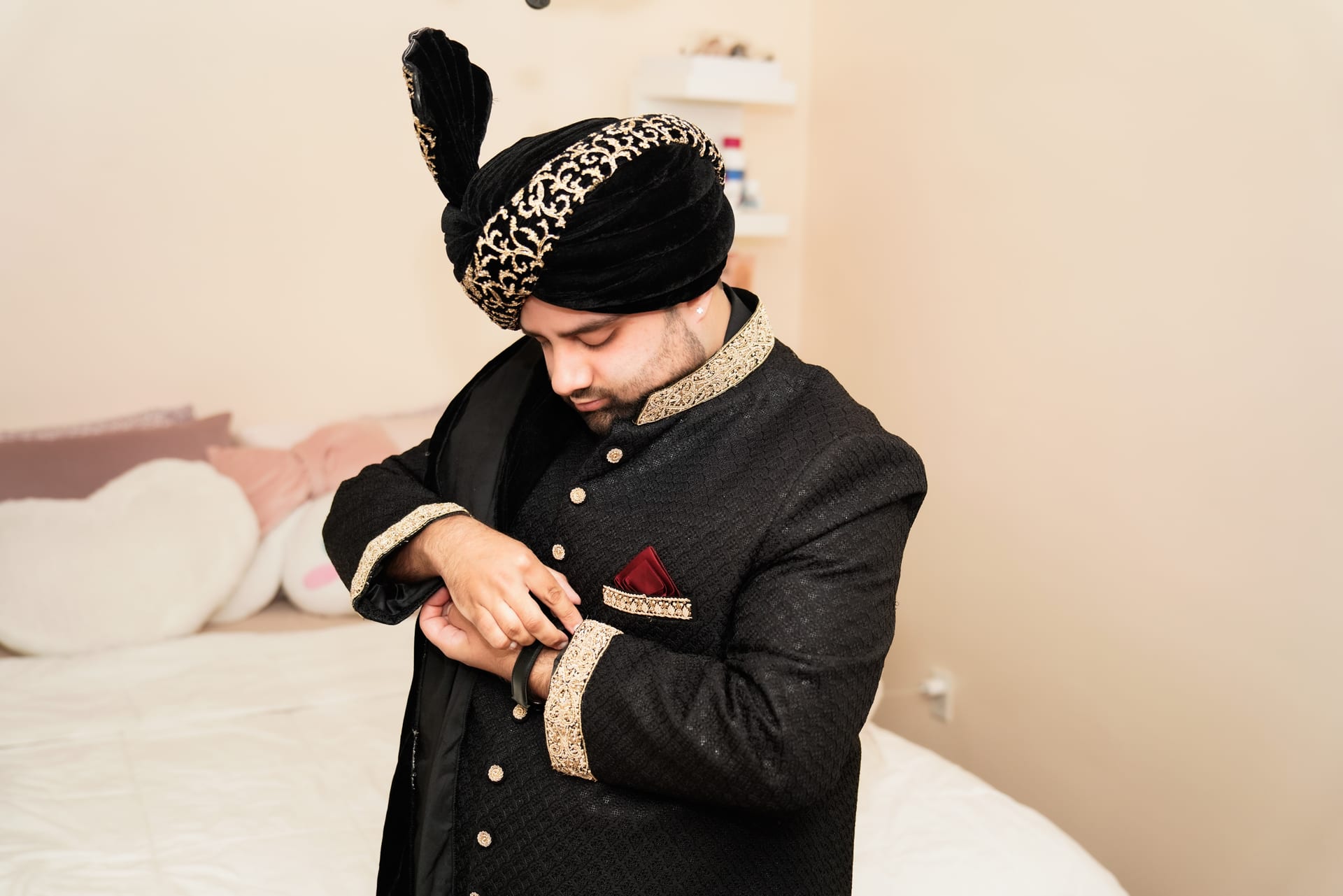 Groom getting ready in embroidered black wedding attire